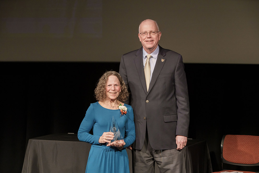 award winner and President Munson posing on stage.