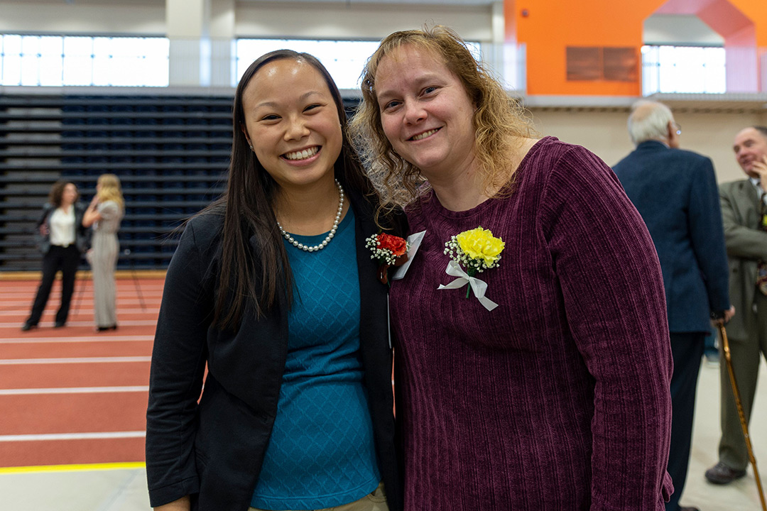 Student and teacher stand next to each other at award ceremony.