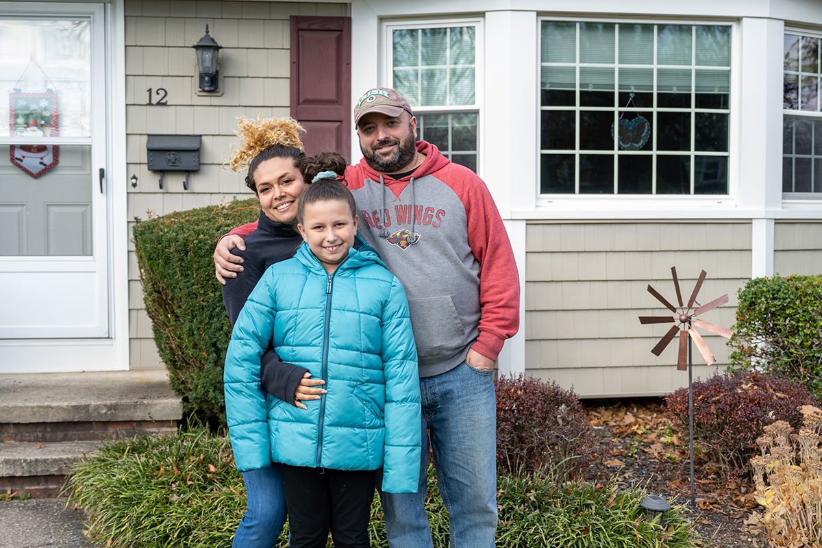 A family portrait of the DeSantis family, consisting of a mother, father and daughter.