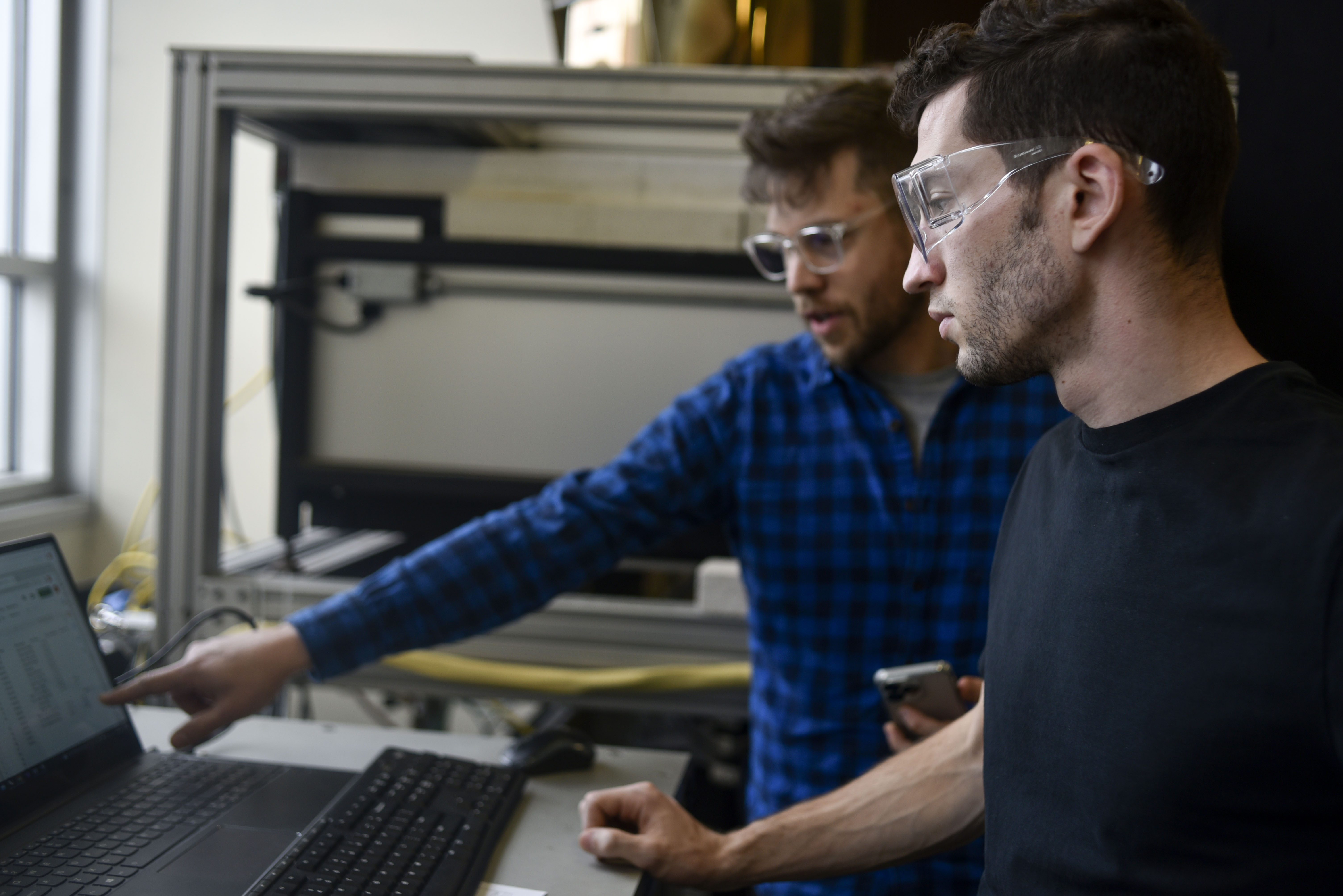 Michael Stern and Raphael Abel look at the computer software that controls a molten glass 3D printer.