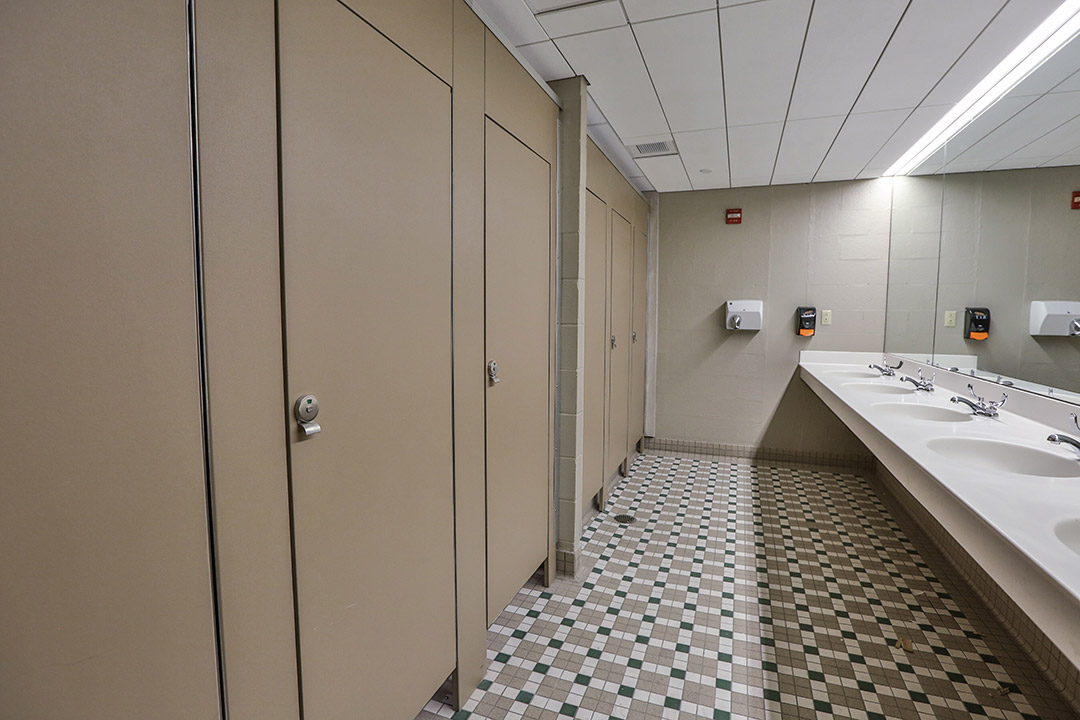a bathroom with multiple stalls and sinks.