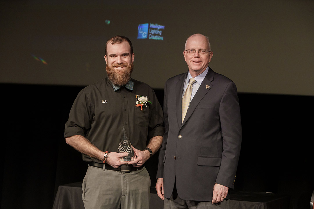 award winner and President Munson posing on stage.