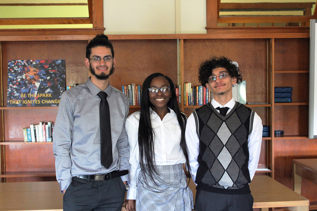 three students posing for a photo in 2018.