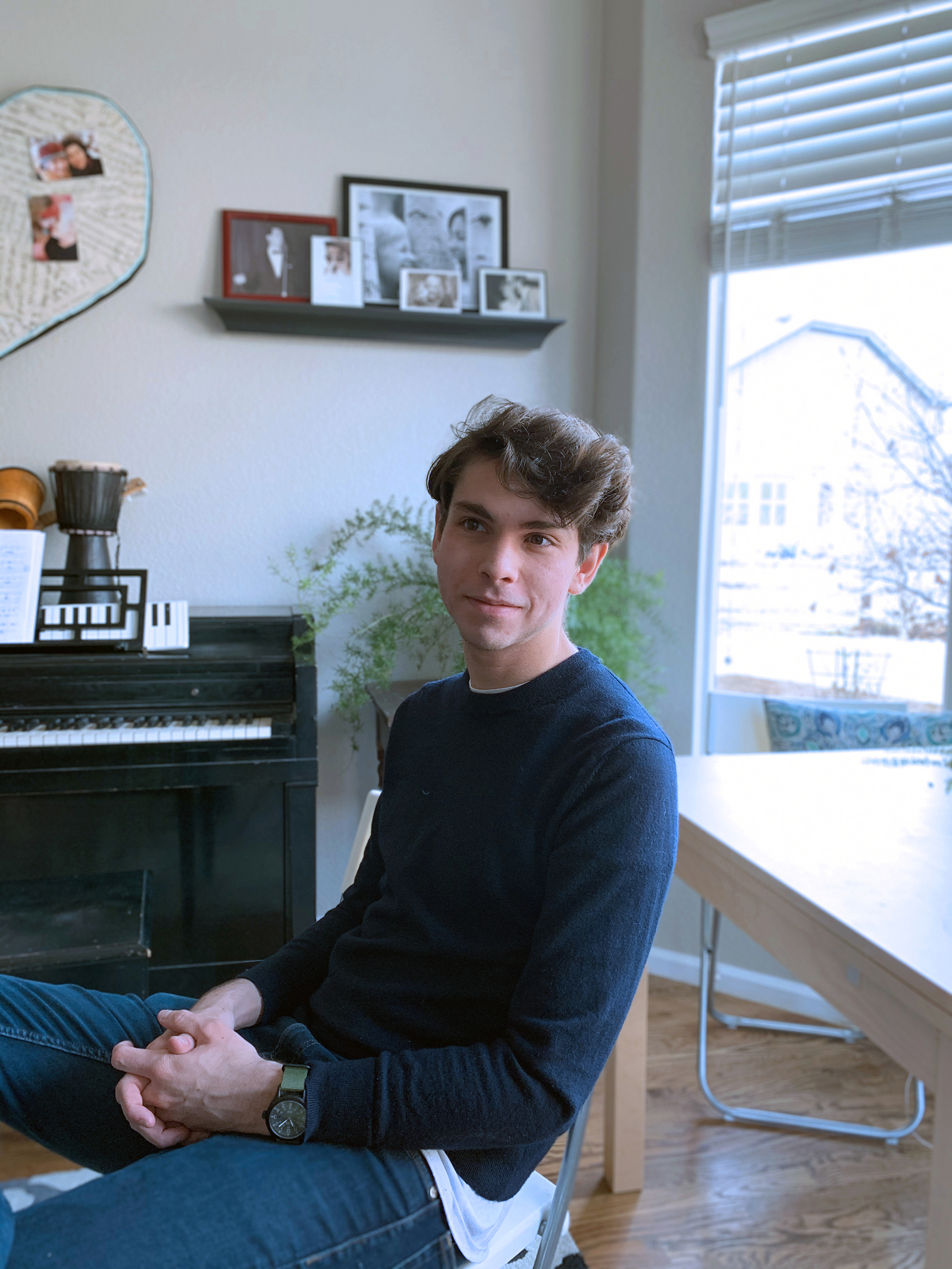 A portrait of Will McCloskey set against a window and piano.