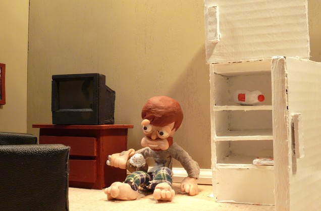 A screenshow from one of the films. Featues a clay man sitting on the floor