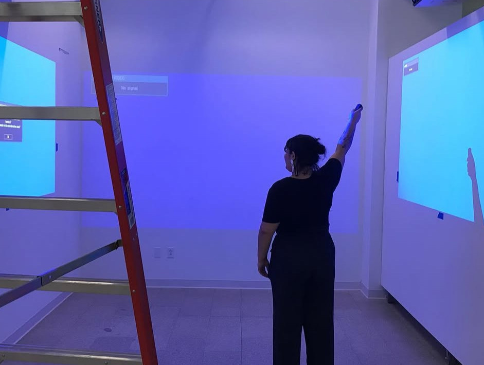 Savannah Cid works on installing a show at City Art Space.