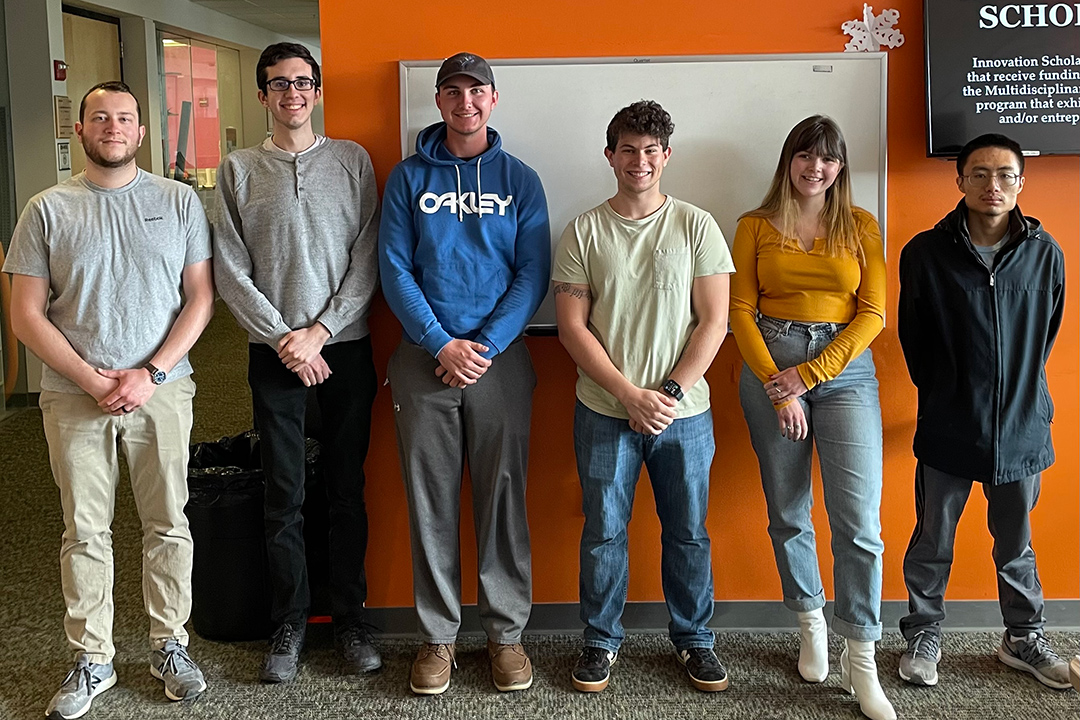 team of six students standing against a wall.