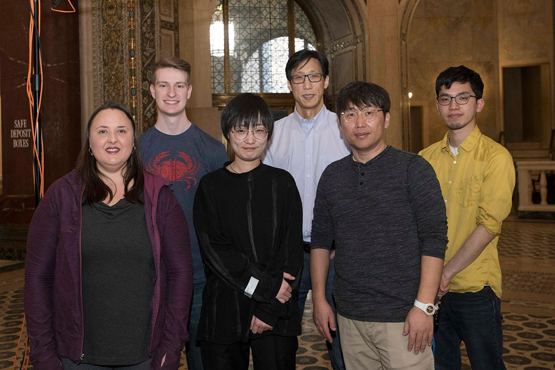 six researchers stand in a historic building.