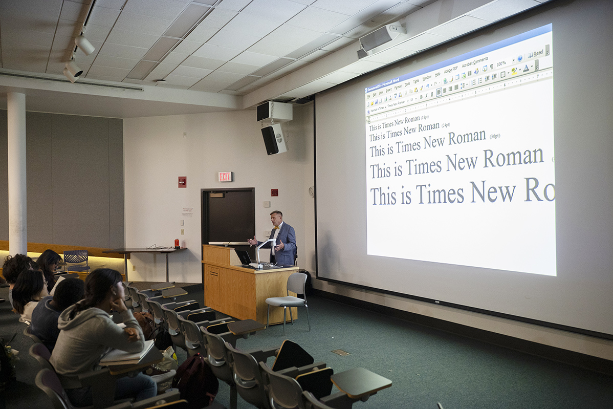 Steve Matteson gives a lecture with typefaces projected on a screen.