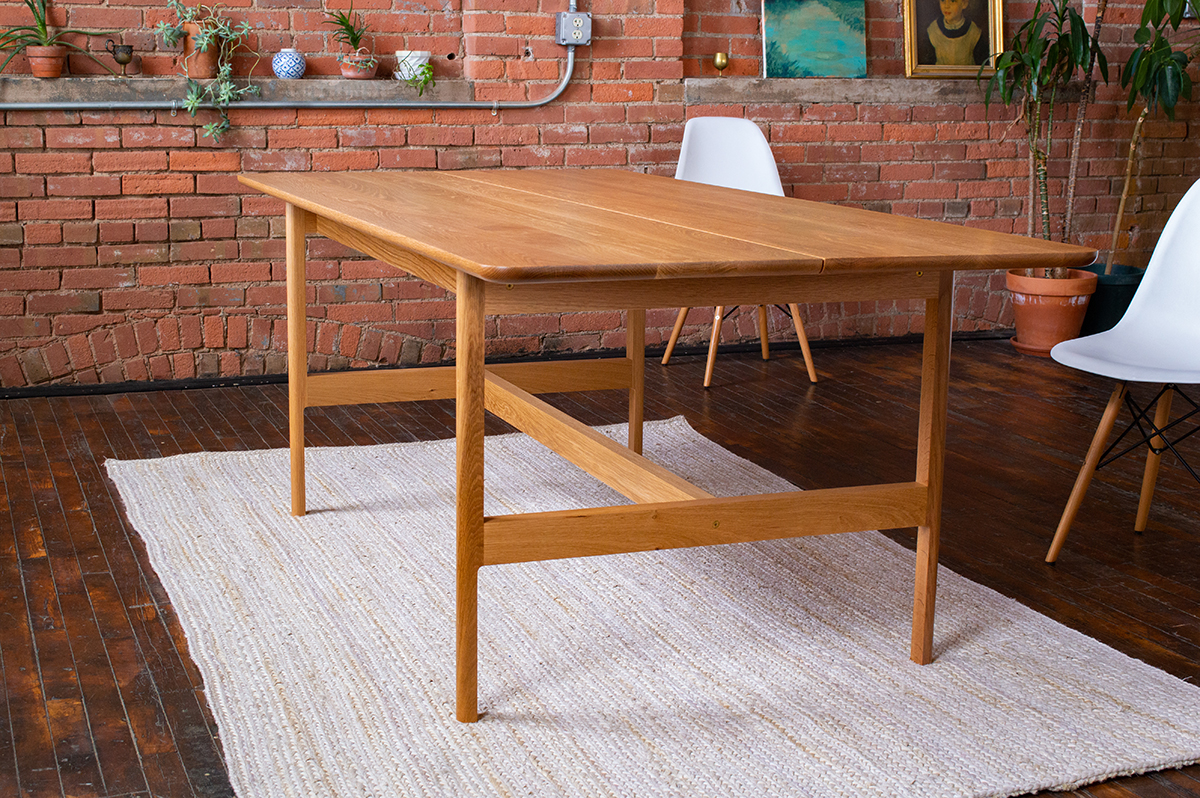 A table designed by Domenic Fiorello sits in an industrial-looking room.