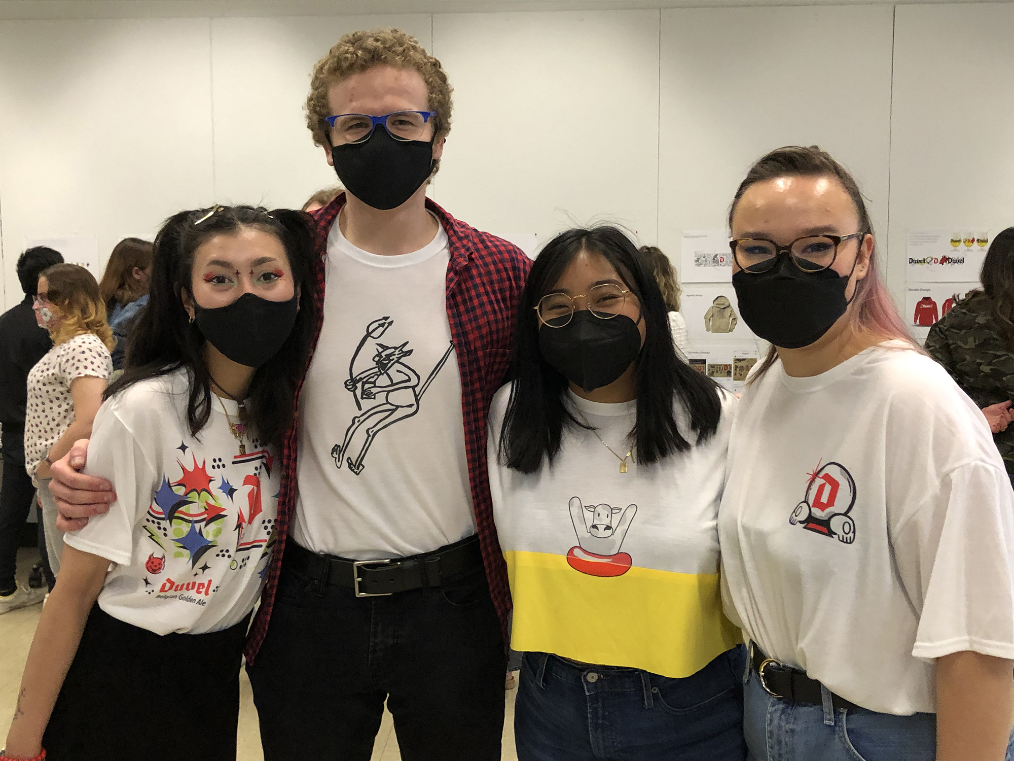 A group of four students wear shirts they designed for a beer company.