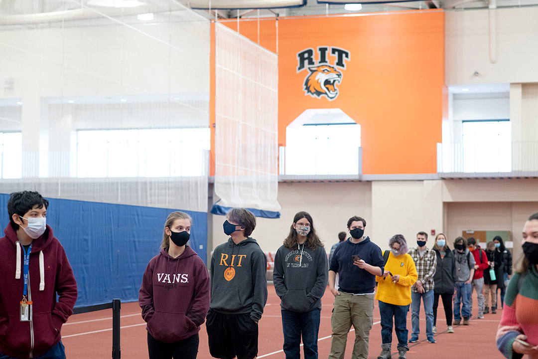 line of students wearing masks in field house.