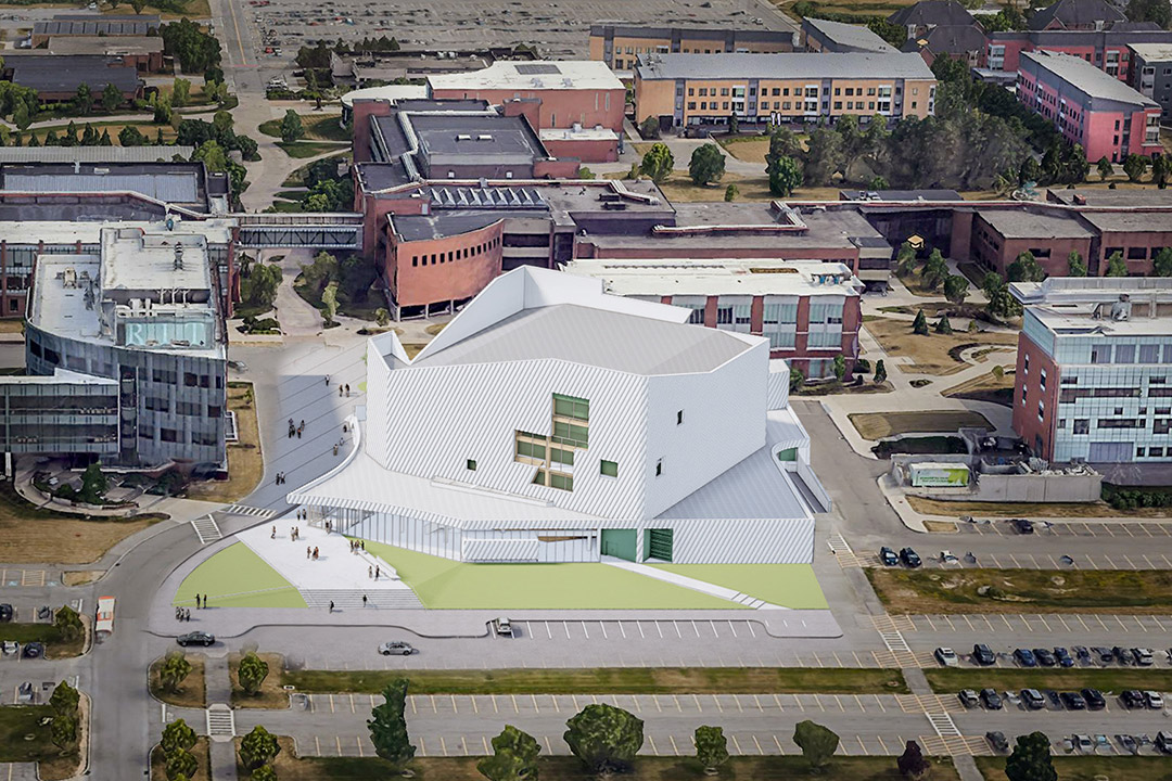 aerial view of a white building in the middle of a college campus.