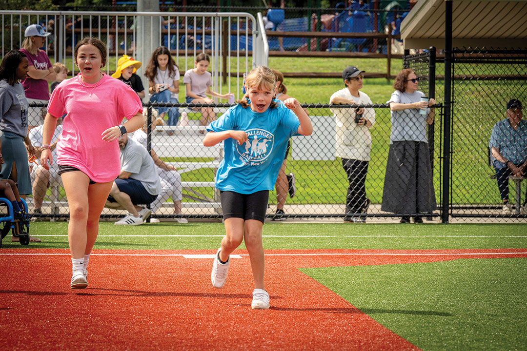 child with a physical disability running on a baseball diamond.