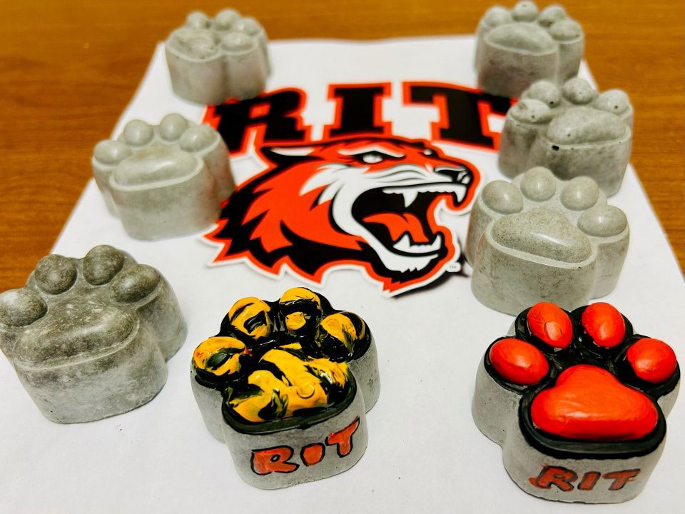 eight concrete tiger paws, with two of them painted.