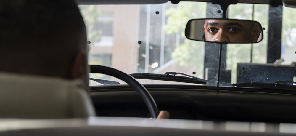 Tiree Walker's eyes seen through a car's rearview mirror.