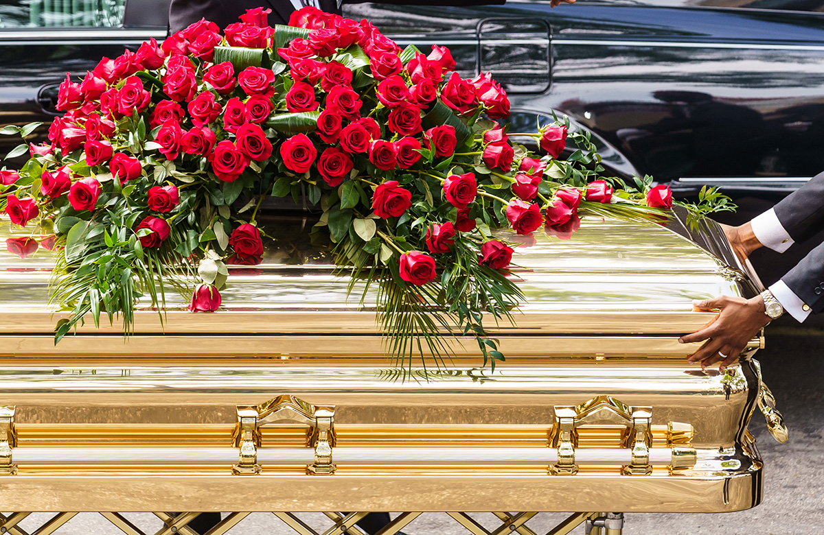 A gold-plated casket holding George Floyd is carried to a hearse at his funeral service.