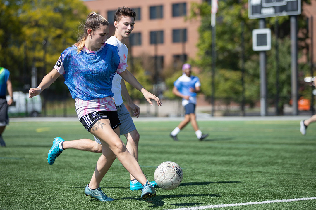 Two students play soccer.