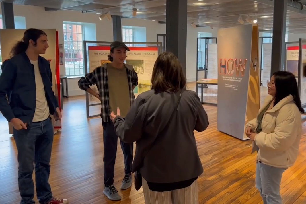 four people talking in a museum space.