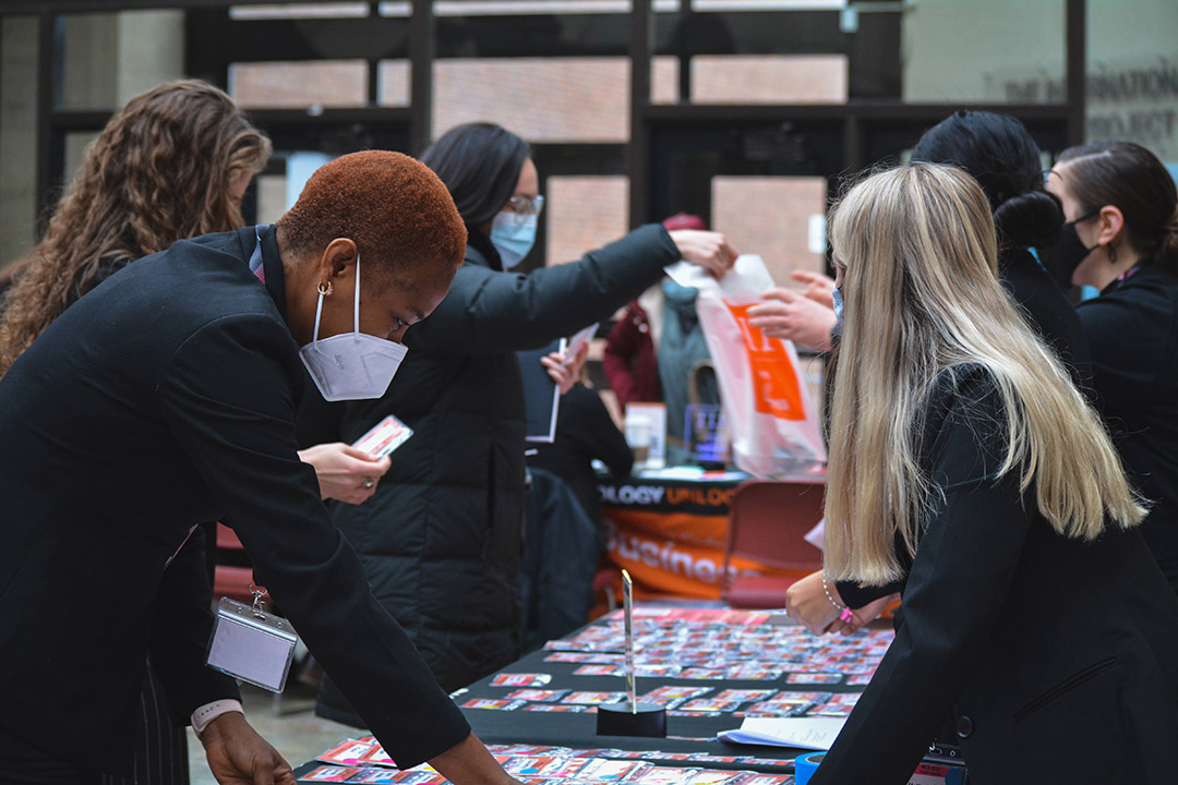 woman taking pamphlets from an information table.