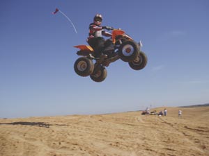 Student testing ATV in sand dunes
