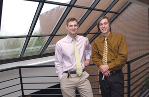 Two students posing by windows