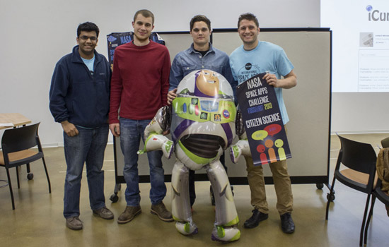 People posing with cardboard figure at event