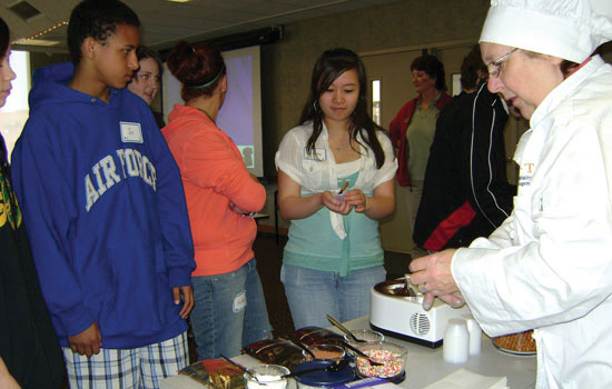 People trying food at event