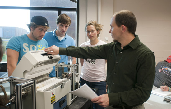 Professor showing students machine