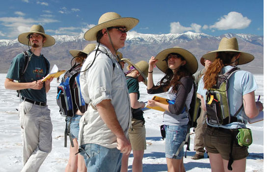 Students taking notes near mountains