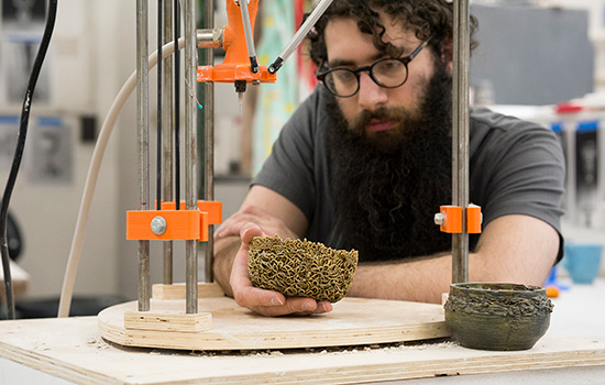 Student uses 3D ceramic printer.