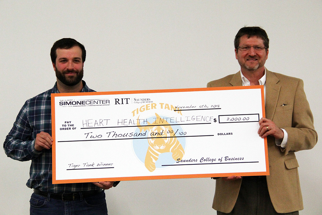 Nicholas Conn and Richard DeMartino hold up a two thousand dollar check; the first place prize for Tiger Tank.