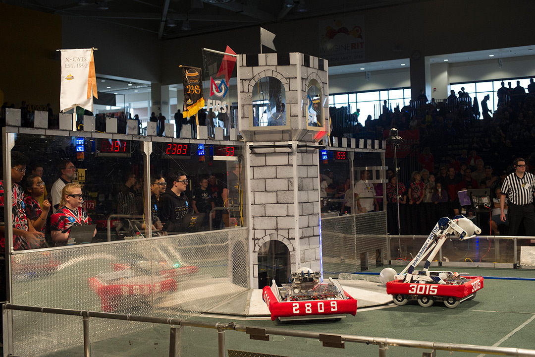 Two teams look on as their robots perform for the competition.