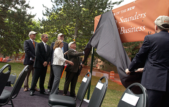 People unveiling "Saunders college of Business" sign at event