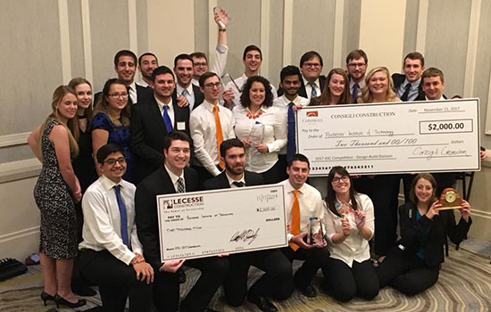 The teams who attended the Associated Schools of Construction annual design competition pose for a photo with their large checks and other awards.