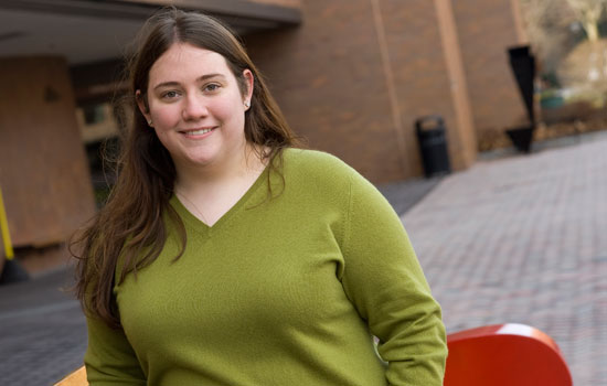 A portrait of Ashley Aberg standing outside the College of Liberal Arts building.