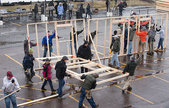 volunteers building framing for a house.