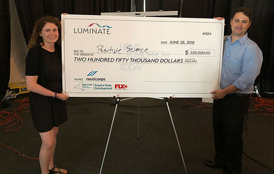 Two people holding large check.