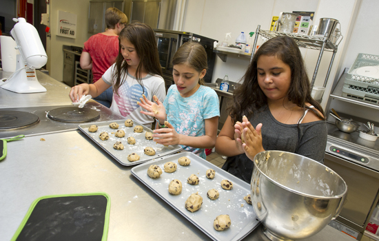 People making cookies in kitchen