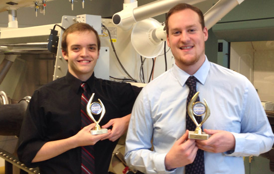 Two people posing with awards in lab