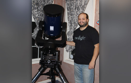 Person posing with giant telescope.