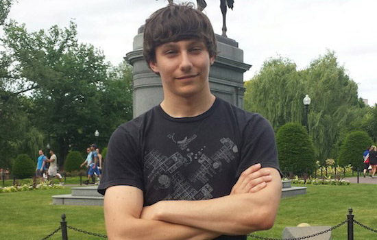 Student posing in front of statue