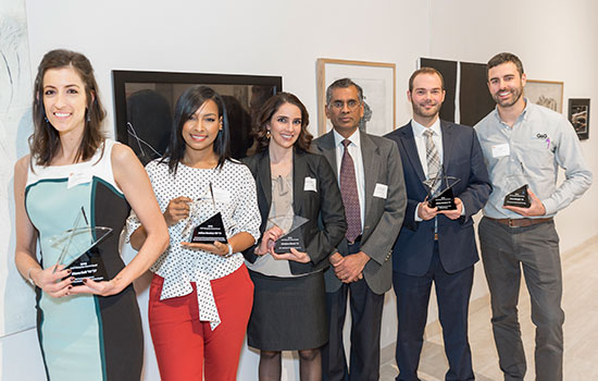 Award winners line up for a photo holding trophies.