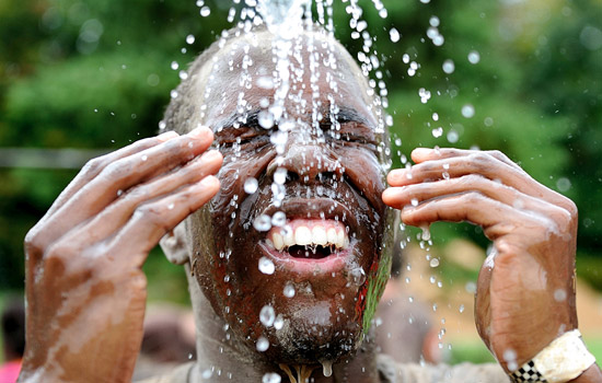 Person outside with water sprinkling on his face.