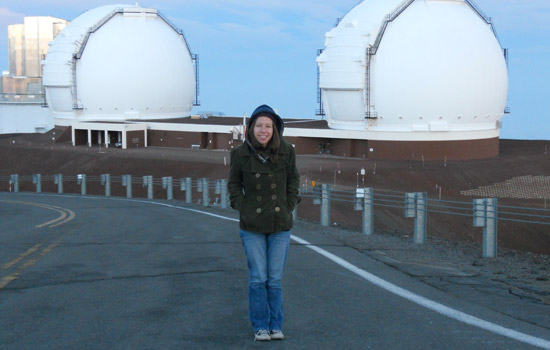Person posing near telescopes