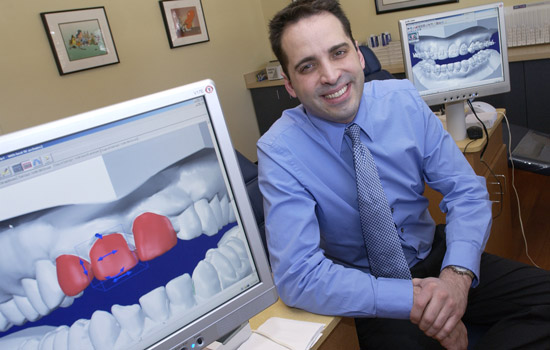 Person posing next to diagram of teeth