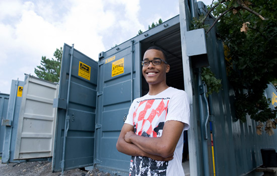 Student standing in front of shipping container