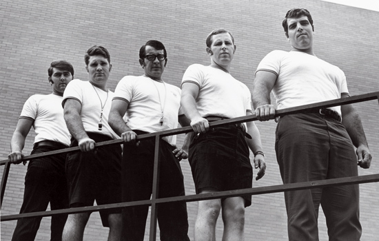 black and white photo of a group lined up against a railing.