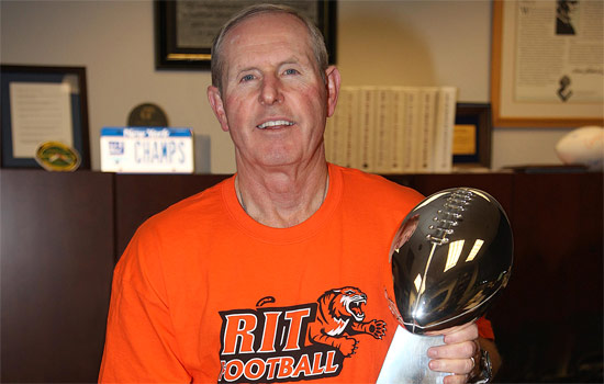 Person in RIT Football shirt holding Super bowl Trophy