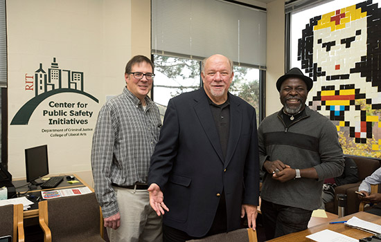 Three people standing in the Center for Public Safety Initiatives office.